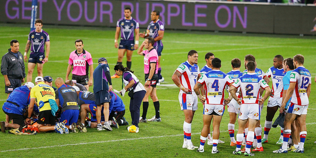 Knights players huddle as Alex McKinnon is prepared to be carried off on a stretcher. Photo / AP