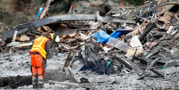 A worker uses a chain saw at the scene of the deadly mudslide in Oso, Washington. Photo / AP