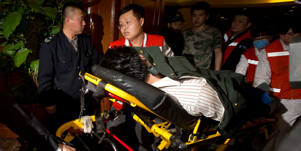 A relative of one of the Chinese passengers aboard the Malaysia Airlines MH370 is taken away on a stretcher. Photo / AP