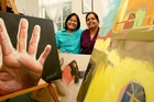 Sonia Pathak and Lisda Anggraeni from Shakti Ethnic Women's Support Group show some of the paintings that will be for sale. PHOTO/RUTH KEBER Sonia Pathak and Lisda Anggraeni from Shakti Ethnic Women's Support Group show some of the paintings that will be for sale. PHOTO/RUTH KEBER