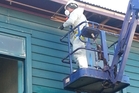 A worker removes asbestos-laden fibrolite panels from the Kaikohe Hotel's eaves. A worker removes asbestos-laden fibrolite panels from the Kaikohe Hotel's eaves.