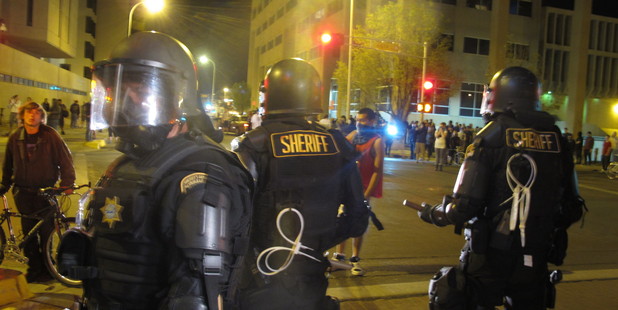 Riot police stand guard in front of protesters in downtown Albuquerque, New Mexico. Photo / AP