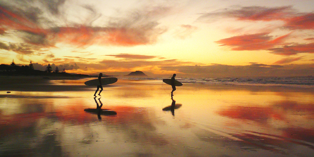 Surfers on Papamoa Beach. Photo / Jon Goldie