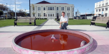 Charlie Fairbairn, council facilities officer, surveys the damage done to tiles and the concrete surround when pink dye was poured into the fountain in the town square over the weekend. Photo/Lydia Feringa