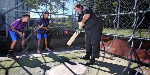Rob Yeoman from ANZ plays a shot in the old nets at Tauranga Intermediate watched by Thomas Friskney and Nensi Patel. Photo/John Borren