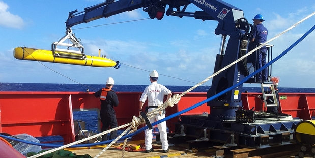 Searchers launch an underwater signal detector from an Oz navy vessel. Photo / Kelli Lunt