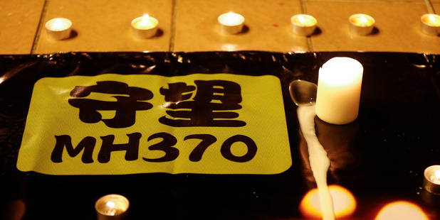 A banner is displayed during a candlelight vigil for passengers onboard the missing Malaysia Airlines Flight MH370. Photo / AP