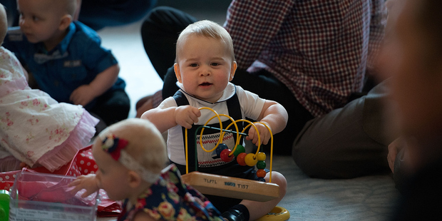 Prince George plays with the toys in front of baby Eden Alve during a Plunket nurse and parents group visit at Government House.