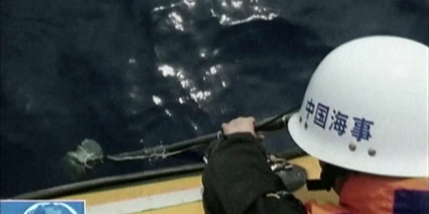 In this image taken from video, a member of a Chinese search team uses an instrument to detect electronic pulses while searching for the missing Malaysia Airlines Flight 370. Photo / AP