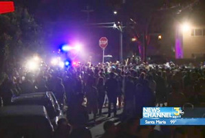 This video image provided by KEYT-TV shows a crowd confronting police during a weekend college party in Southern California that devolved into a street brawl. Photo / AP