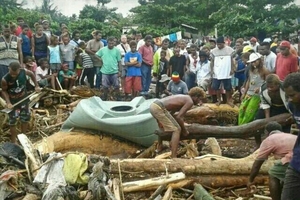 Solomon Islanders in Honiara recover what they can from the debris left by floodwaters.