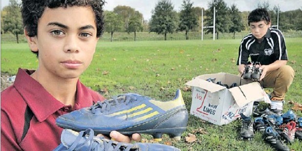 TREASURE: Michael Hoffman, 13, holds his most prized pair of boots, signed by Hurricanes stars Beauden Barrett and TJ Perenara, before putting them into the box with 15 other pairs the family's donating to the Hawke's BayToday Bring yer Boots campaign. At right is brother and rugby player Rocky, 14.