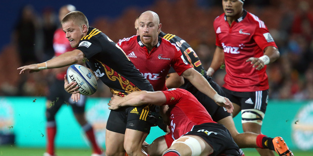 Gareth Anscombe looks for support in the tackle of Kieran Reid. Photo / Getty Images