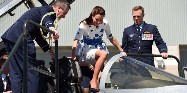 The Duchess of Cambridge tries out the cockpit of a jet fighter in Brisbane helped by Air Marshal Geoff Brown and Wing Commander Stephen Chappell. Photo / Getty Images