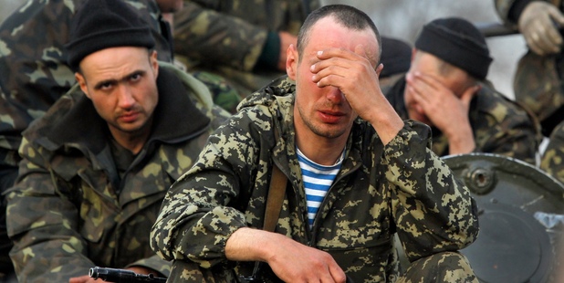 Soldiers from the Ukrainian Army sit atop combat vehicles as they are blocked by people on their way to the town of Kramatorsk. Photo / AP