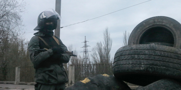 Armed pro-Russian activist stands at a makeshift checkpoint at the entrance into the eastern Ukrainian town of Slovyansk. Photo / AP