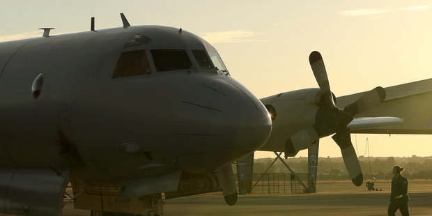 A flight crewman from a Royal Australian Air Force P-3 Orion walks towards the aircraft at RAAF Base Pearce. Photo / AP