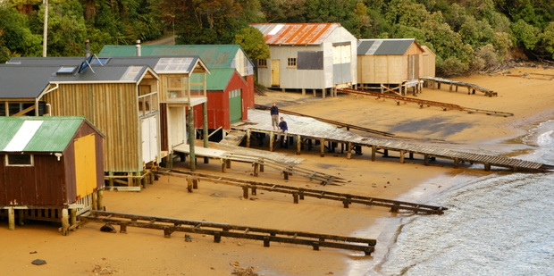 Colourful boat sheds on one of Stewart Island's lovely beaches.