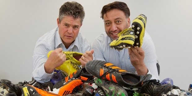 Sports reporter Shane Hurndell (left) and chief reporter Greg Taipari pictured with boots donated by the public for the Bring yer Boots campaign. Photo/Glenn Taylor