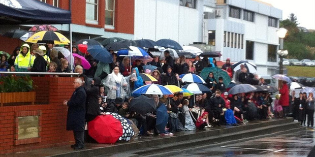 Crowds sheltering under umbrellas as they wait for the royal couple. Photo / Rebecca Quilliam
