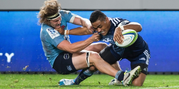 Michael Hooper of the Waratahs tries to stop Francis Saili on his way to the line at Eden Park last night. Photo / Greg Bowker