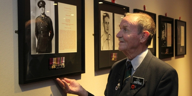 Hastings RSA stalwart John Stables with the framed tribute to VC winner Keith Elliott, who had links to the Hawke's Bay. Photo / Duncan Brown