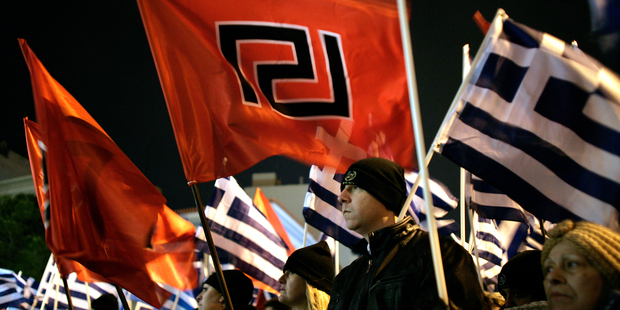 Supporters of ultra nationalist party Golden Dawn hold party flag and Greek flag . Photo / AP