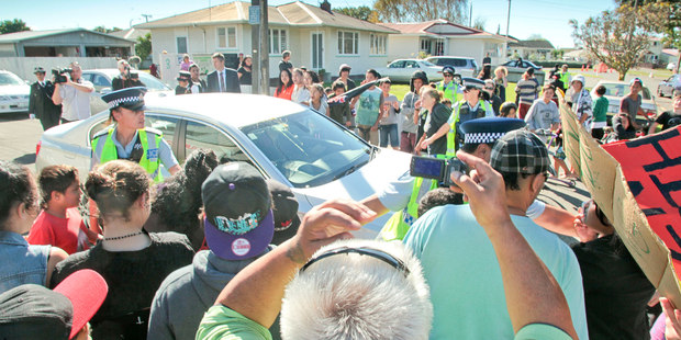 Police keep the crowd of protestors back as the Prime Minister John Key leaves after opening new State Houses in Maraenui, Napier. Photo / Warren Buckland
