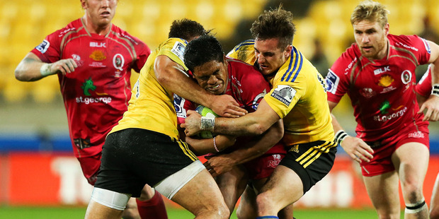 Ben Tapuai of the Reds is tackled by Jack Lam and Andre Taylor of the Hurricanes during the round 11 Super Rugby match between the Hurricanes and the Reds. Photo / Getty Images.
