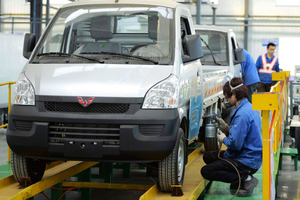 Workers put the finishing touch to a pickup at a factory of SGMW, a joint venture between Chinese carmakers and General Motors in Qingdao in east China's pic/AP