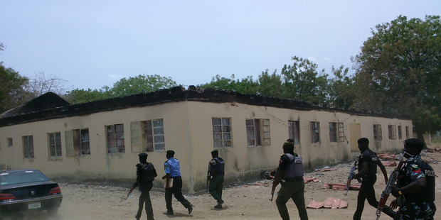 Security walk past burned government secondary school Chibok, where gunmen abducted more than 200 students in Chibok, Nigeria. Photo / AP