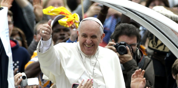 Pope Francis waves to faithful as he is driven through the crowd for his weekly general audience, in St. Peter's Square, at the Vatican. Photo / AP