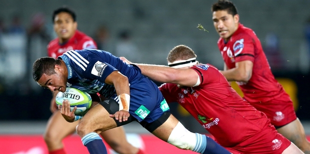 Blues halfback Bryn Hall attempts to break the tackle of Reds prop James Slipper last night. Hall had a strong game. Photo / Getty Images