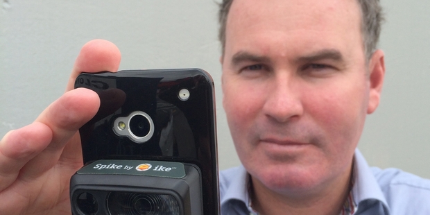 ikeGPS managing director Glenn Milnes with the firm's new Spike device, which attaches to a smartphone.