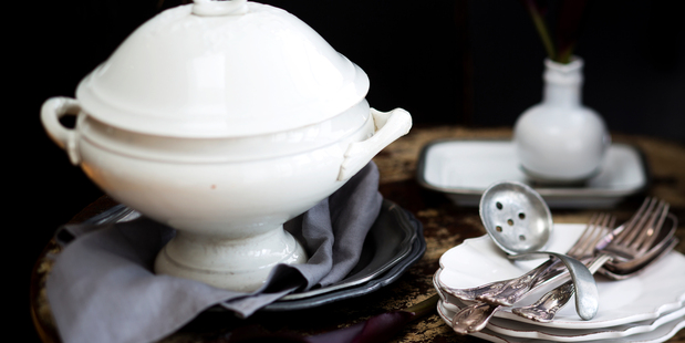 Antique distressed table, pewter plates, French serving dish, white bowl from Romatique. Photo / Babiche Martens