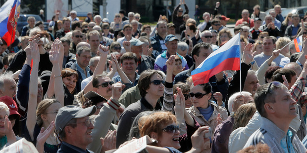People wave Russian flags during a pro-Russia rally at Lenin square, Donetsk, Ukraine. Photo / AP