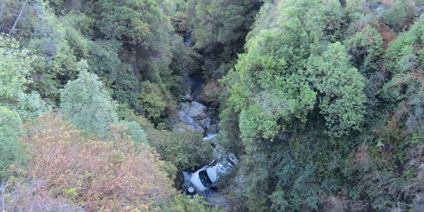 The Toyota Highlander SUV which left Kingston Rd, crashed through the road barrier and scrub and fell 30m into Wye Creek early yesterday. Photo / James Beech / Otago Daily Times