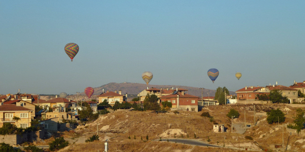 Brightly-coloured balloons, some flying low, in the sky over Cappadocia. Photo / Justine Tyerman
