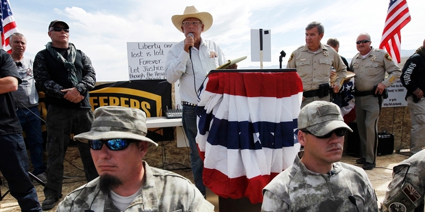 Rancher Cliven Bundy (centre) addresses his supporters beside Clark County Sheriff Doug Gillespie (right) while being guarded by militia members. Photo / AP