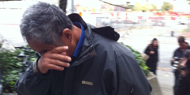 Cunbin Zhang hides his face as he heads into the Christchurch District Court today. Photo / APNZ