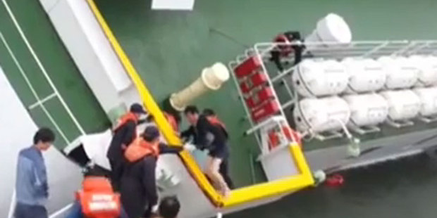 A screenshot from coastguard video of the captain of the doomed ferry being rescued as hundreds remained trapped inside his ship. Photo / AP