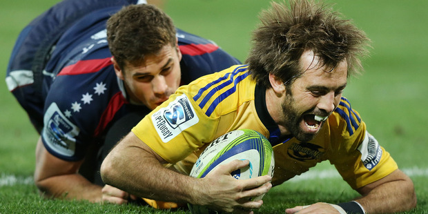 Conrad Smith of the Hurricanes scores a try past Tom English of the Rebels. Photo / Getty Images