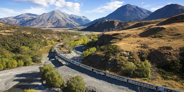 The TranzAlpine cruises around a river bend on its Southern Alps traverse of the South Island.