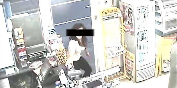 This CCTV image shows the young woman just before she lunges for the St John donation box and runs out the door.