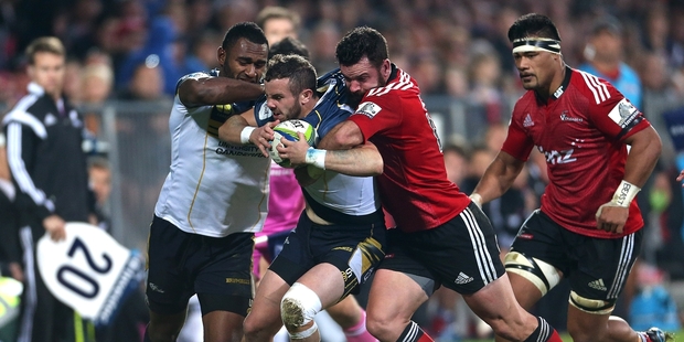Brumbies utility Robbie Coleman is collared by Crusaders midfielder Ryan Crotty. Photo / Getty Images