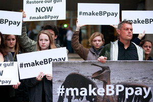 Activists holds signs during a protest in front of the Hale Boggs Federal Building on the first day of the first trial. Photo / Getty Images