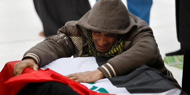 Mohammed Layth Ahmed weeps over the coffin of his father, Layth Ahmed, an Iraqi soldier, in the city of Najaf. Photo / AP