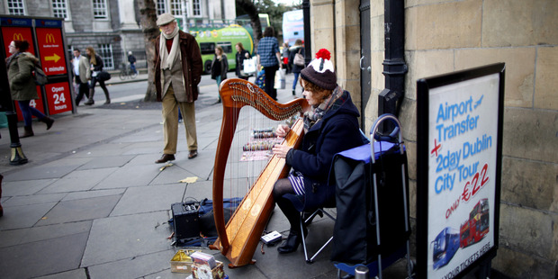 A woman plays the harp in Dublin city centre, Ireland. On Sunday, Ireland officially ends its reliance on a 67.5 billion-euro loan program.