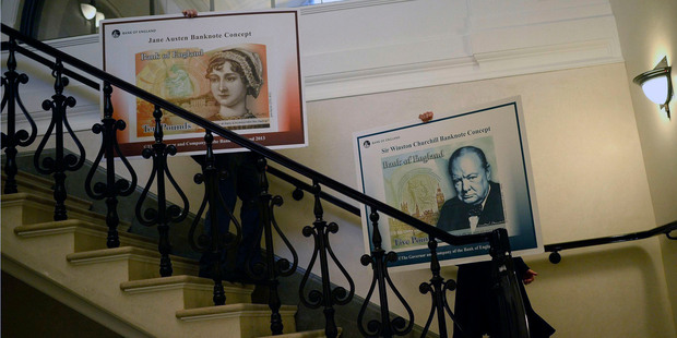 Victoria Cleland, right, and Mark Cornelius carry posters showing the design of the new polymer banknotes as they pose for the media after a news conference at the Bank of England. Photo / AP