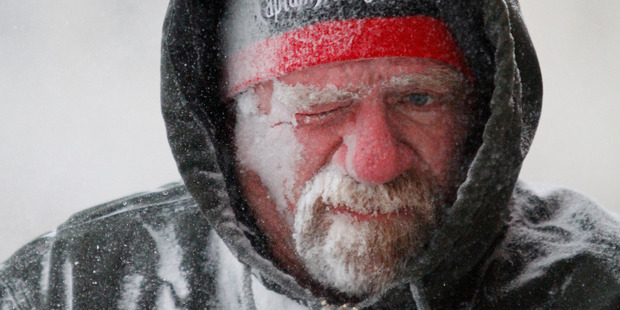 Allan Umscheid, owner of Yards By Al in Lawrence, Kan, feels the bitter wind as he runs a snow blower early Sunday morning. Photo / AP